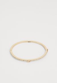 Bracciale a bangle in tonalità oro con una finitura liscia, impreziosito da strass trasparenti lungo un lato e una chiusura a gancio. Logo visibile all'interno.