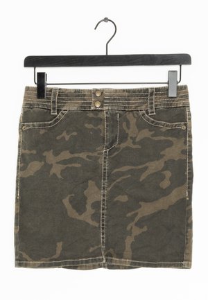 Minifalda con estampado de camuflaje, dos bolsillos delanteros, cierre doble con botones y costuras visibles en una percha negra.