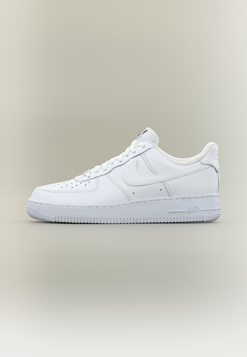 Λευκό χαμηλό sneaker Nike Air Force 1 με διάτρητο μπροστινό μέρος, κλείσιμο με κορδόνια και εμφανές λεπτομερές αερόσολας σε ουδέτερο φόντο.