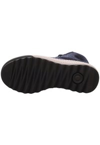 Suola di scarpa blu navy con gomma nera testurizzata, caratterizzata da un motivo a zigzag e un dettaglio circolare vicino al tallone.