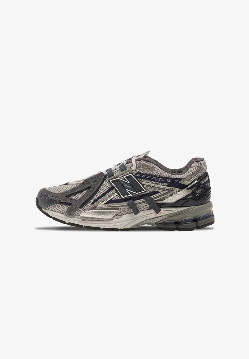 Scarpa da corsa New Balance grigia e nera con tomaia in mesh, logo laterale, ammortizzazione visibile nella suola e design sovrapposto dettagliato.