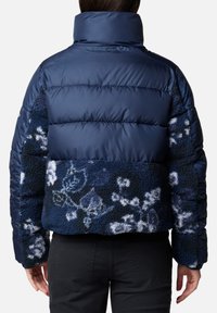 Giacca imbottita blu navy con retro in sherpa texturizzato e motivi floreali, colletto alto e design cropped. Resistente e caldo.