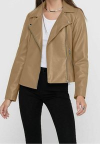 Giacca da biker in ecopelle color tan con zip frontale, colletto a scatto e finitura testurizzata. Presenta dettagli in metallo argentato e un design aderente.