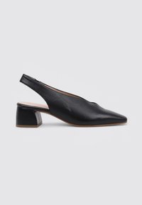 Zapato slingback de cuero negro con un diseño de punta afilada y un tacón bajo. Textura suave con acentos mínimos.