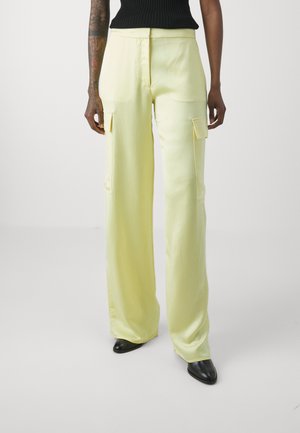 Yellow wide-leg trousers made of smooth fabric, featuring cargo pockets, a relaxed fit, and a clean waistband with zipper closure.