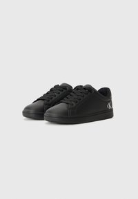 Svarta sneakers med en slät, syntetisk ovandel, rund tå, platta snören, perforerade detaljer på sidorna och en liten logotyp på hälen.