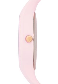 Montre en silicone rose à profil fin, avec des accents métalliques et un cadran rond. Elle présente une couronne ronde simple en ton or.