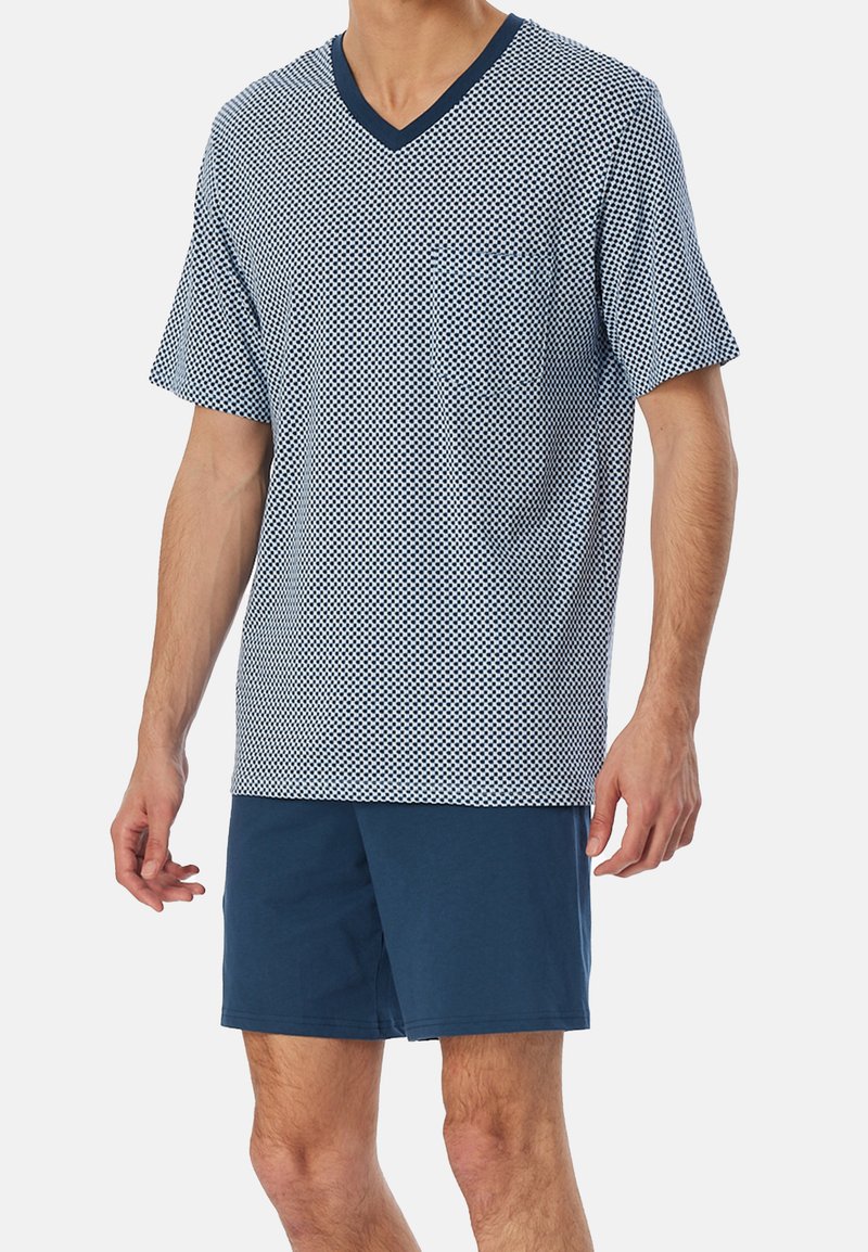 Navy and white geometric patterned short-sleeve V-neck shirt paired with solid navy shorts, featuring a relaxed fit and soft texture.