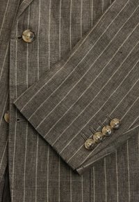 Brown striped linen blazer featuring two front buttons and five button accents on the cuff. Textured fabric with a tailored fit.