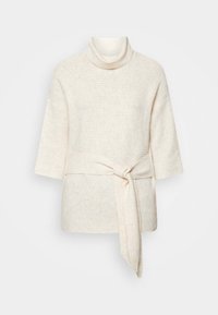 Pull en maille couleur crème avec manches trois-quarts, col roulé et une large ceinture en tissu nouée en nœud à la taille.