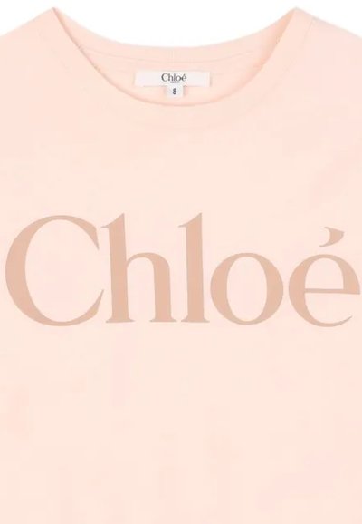 Jasnoróżowa koszulka T-shirt z dużym, subtelnym beżowym logo „Chloé” na przodzie. Gładki bawełniany materiał z okrągłym dekoltem.