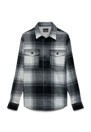 Black and white plaid flannel shirt with long sleeves, two front pockets, button closure, and a rounded hem. Soft texture and classic design.