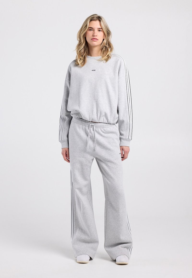 Grauer Pullover und Jogginghose aus Baumwollmischung, mit schwarzen Seitenstreifen und elastischem Bund, entspannter Passform und gerippten Bündchen.