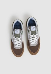 Sneaker marrone e grigio con pannelli in rete, lacci bianchi e dettagli verdi. Etichetta sul tallone con la scritta "Pepe Jeans LDN." Punta in suede.