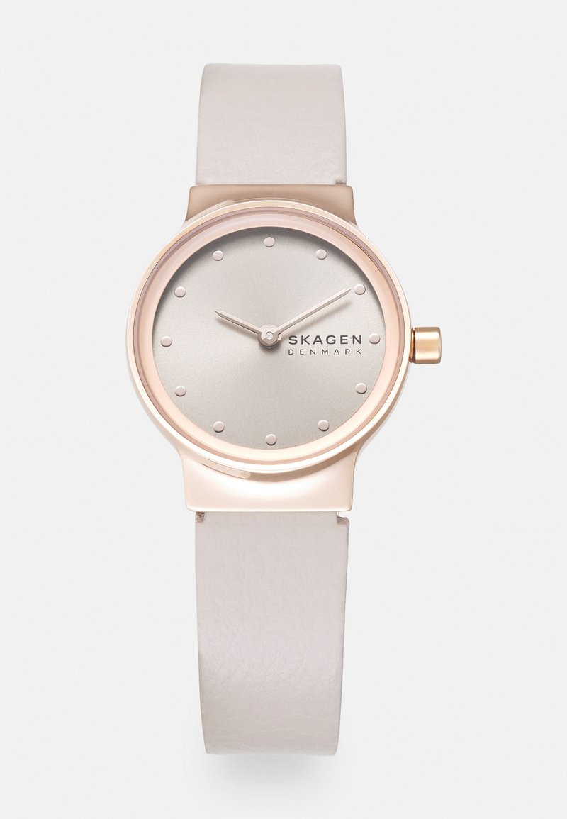 Pink gold-tone watch with a silver dial, minimalist dot markers, and a smooth white leather strap. Simple design with a sleek, modern look.