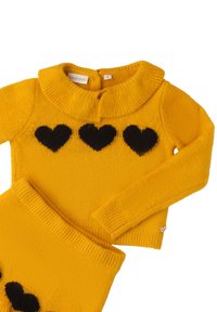 Set in maglione giallo a maglia con colletto a coste e tre motivi a cuore neri sul petto, con vita a coste coordinata.