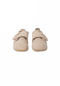 Beige stoffen schoenen met een gestructureerd oppervlak, klittenbandsluiting en flexibele rubberen zolen. Zacht, rond ontwerp zonder zichtbare patronen.