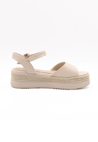 Beige platform sandals with open toe, wide strap, and adjustable ankle strap. Jute-like textured midsole and rubber sole for grip.