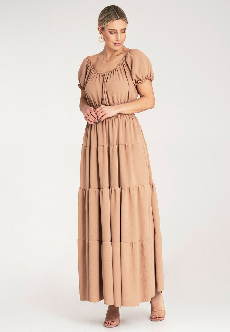 Sukienka maxi w jasnym beżu, z krótkimi bufkami, marszczonym pasem i warstwową spódnicą o subtelnej teksturze oraz zwiewnym kroju.