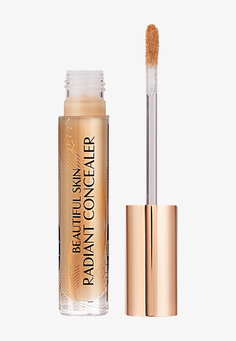 Klarer Behälter mit beige flüssigem Concealer, beschriftet mit "Beautiful Skin Radiant Concealer", mit rosegoldenem Deckel und Applikatorstab daneben.