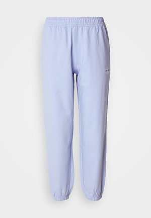 Jasnoniebieskie bawełniane dresy z elastycznym paskiem w talii, zwężanymi nogawkami i małym logo wyszytym po boku. Gładka tekstura.