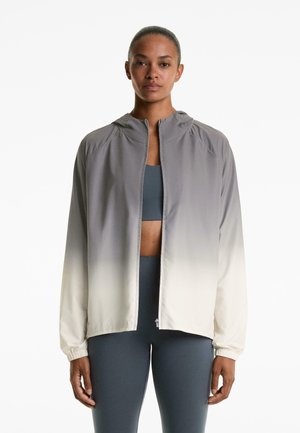 Lightweight, gradient zip-up jacket with a hood, transitioning from gray to white, featuring elastic cuffs and a smooth, functional fabric.