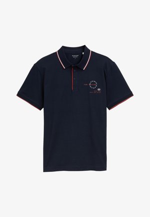Navy blue polo shirt with red and white accents, three-button placket, and a front logo print. Made of cotton, featuring short sleeves.