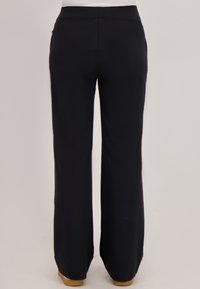 Zwarte, wijde broek met een gladde, rekbare stof. Voorzien van een eenvoudige tailleband en achterzakken, ontworpen voor comfort en gemak.