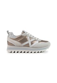 Sneaker sportive con un mix di materiali in pelle scamosciata grigia e metallo argentato, caratterizzate da una striscia bianca e una suola spessa e rigida.