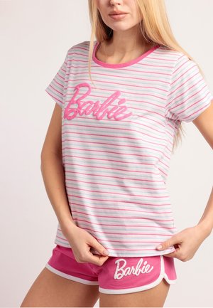 Mujer con camiseta de rayas blancas y rosas y pantalones cortos rosas, ambos con el texto "Barbie" en letra cursiva.