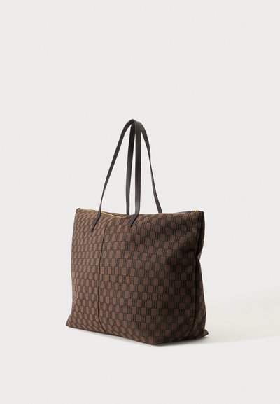 Sac cabas à carreaux marron avec des bretelles en cuir noir et une fermeture éclair sur le dessus, sur fond blanc uni.