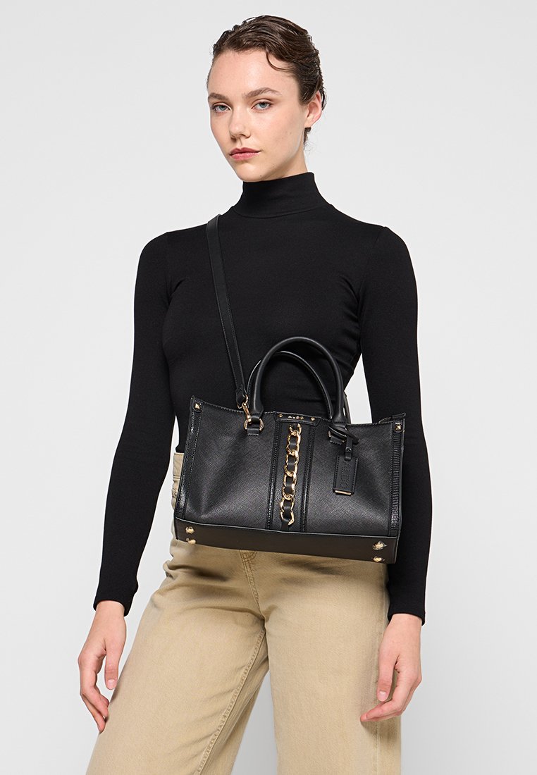 Borsa a mano nera in pelle con doppio manico e tracolla rimovibile. Presenta dettagli in catena dorata e una superficie testurizzata. Hardware metallico visibile.