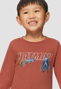 Bruine lange mouwshirt met een grafische print van Batman en een Batmobile in blauw en oranje, gemaakt van zachte katoen.