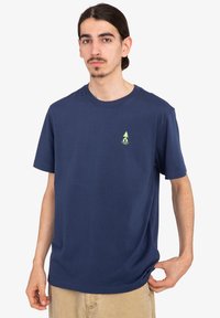 Navy blue cotton t-shirt with short sleeves and round neck; features a small yellow tree logo on the left chest. Simple design, relaxed fit.
