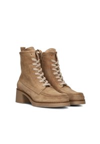 Une paire de bottines en daim beige avec des talons épais, des fermetures éclair sur le côté et des lacets beiges sur fond blanc.