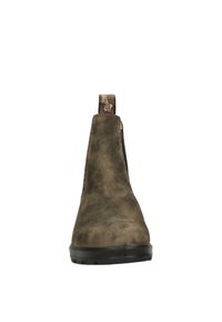 Bota de tobillo de cuero marrón con un acabado liso, paneles laterales negros y una suela de goma texturizada; cuenta con una lengüeta en la parte posterior.