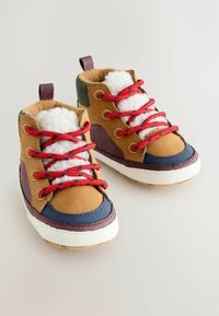 Wanderschuhe mit Obermaterial aus braunem Wildleder, roten Schnürsenkeln und weißem Kunstfellfutter. Mit mehrfarbigen Akzenten in Marineblau und Burgunder.