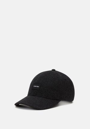 Dark gray Calvin Klein baseball cap with curved brim and fabric patch logo on front, angled on a light background.