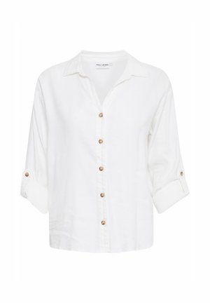 Balts krekliņš ar pogām, izgatavots no kokvilnas maisījuma. Iezīmēts ar apkakli, sarullētām piedurknēm un zeltaini toņu pogām gar priekšu un piedurknēm.