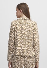 Braun-weiße gemusterte Blazer mit geometrischem Design, taillierte Passform, lange Ärmel und Reverskragen, von hinten gezeigt.