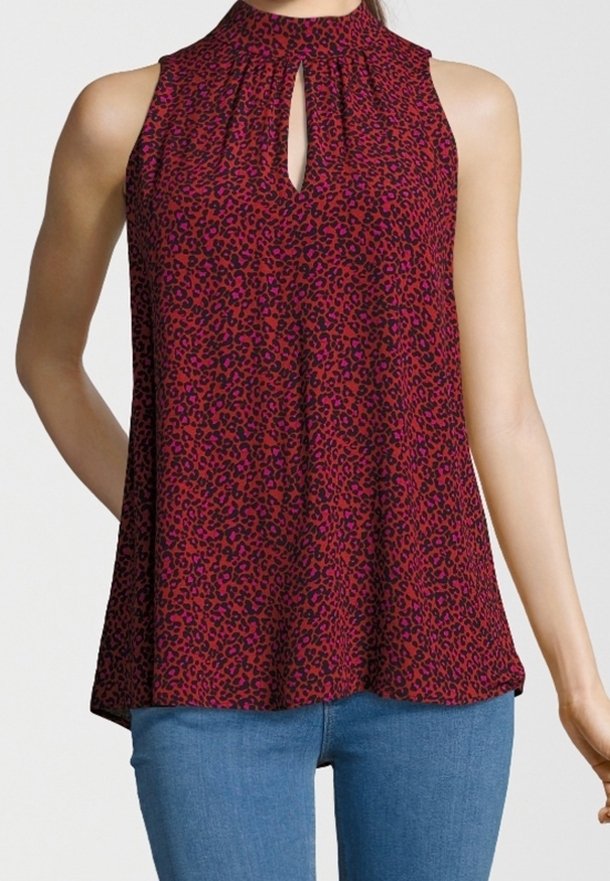 Sleeveless red and purple leopard-print blouse with keyhole neckline worn with blue jeans on a person against a plain background.