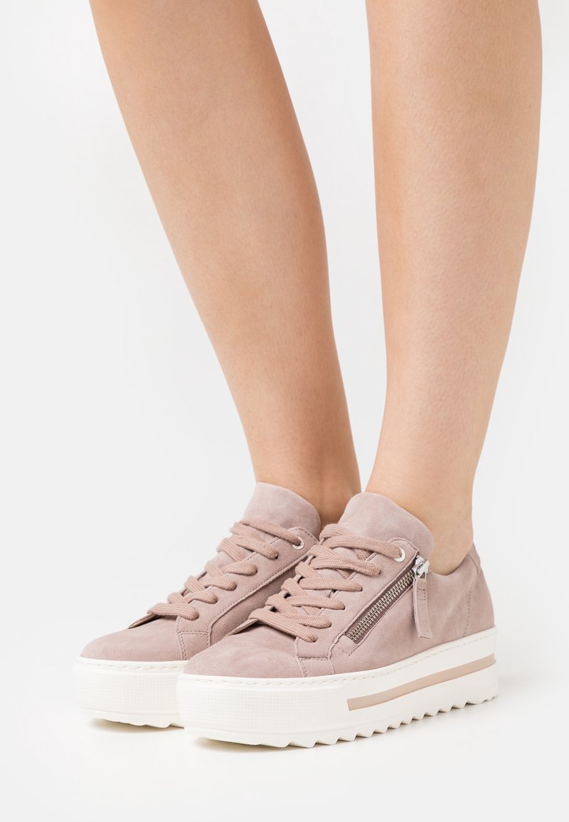 Rosa mockasneakers med vadderad krage, snörning fram och en sidodragkedja. Vit platåsula med zigzagmönster.