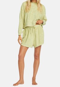 Hellgrüne Lounge-Set bestehend aus einem strukturierten Pullover und passenden Shorts. Beide Teile haben einen elastischen Bund und dezente Blattmuster.