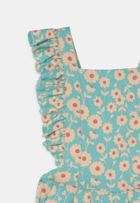 Blumenkleid mit einem türkisfarbenen Hintergrund, das pinke und cremefarbene Blumen zeigt, Rüschenträger hat und tailliert ist. Aus weicher Baumwolle.