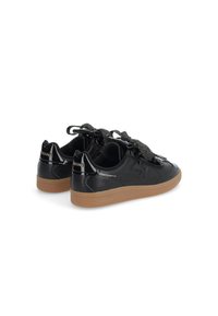 Black patent leather sneakers with a textured black tongue, wide sparkly laces, and a gum sole. Branding on the heel. Low-top design.