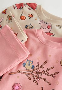 Kolme lasten collegepaitaa. Vaaleanpunainen, jossa pöllökuvioita; beige, jossa värikkäitä sarjakuvakuvioita; kaikki ovat pehmeää puuvillakangasta ja ribbauslahkeilla.