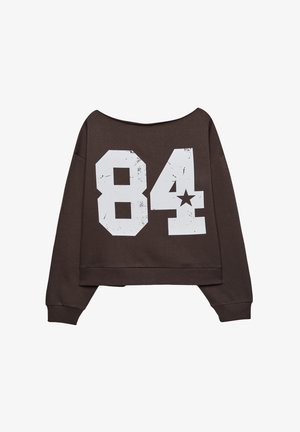Brauner, cropped Sweatshirt mit einem schulterfreien Design, das große, weiße, abgenutzte Zahlen "84" und eine Stern-Grafik auf dem Rücken zeigt.