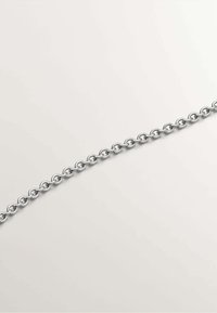 Cadena de metal plateado con eslabones ovalados, superficie pulida y un diseño uniforme, adecuada para uso en joyería o accesorios.