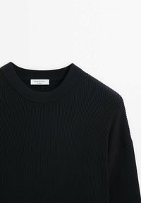 Black ribbed knit sweater with a round neck. Features dropped shoulders and a textured fabric. Label visible inside collar.