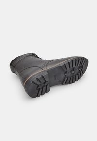 Botine negre din piele, cu finisaj texturat, talpă robustă din cauciuc cu model adânc și fermoar lateral pentru acces facil.